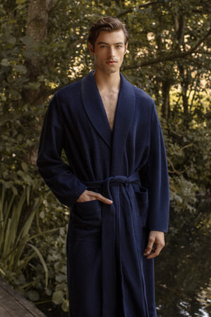 Man stands by a tranquil lakeside wearing MANITO's Navy Blue Wool Silk Knit Robe, blending elegance with leisure.