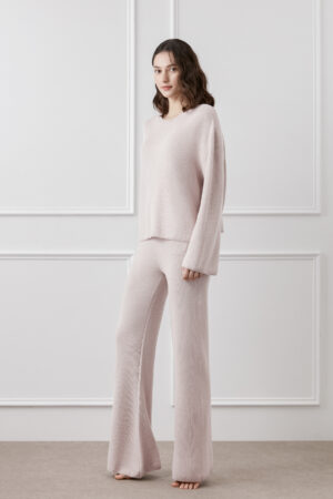 Woman wearing Mellow Silk-Wool-Cashmere Lounge Set in cotton pink, showcasing relaxed fit and flowing wide-leg pants.