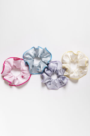 Collection of Macaron Large Silk Scrunchies in pink, blue, lavender, and cream arranged on a white background.