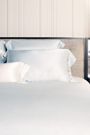 MANITO Authentic Silk Pillowcase Set in blue displayed neatly on a bed, creating an elegant bedroom atmosphere.