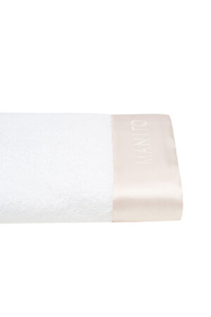 Close-up of silk-trimmed towel from Blush Bath Gift Set with MANITO logo.