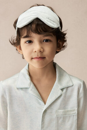 Child wearing BONPOINT×MANITO Clive Kid's Pajama Set Gift Box with matching embroidered silk eye mask.