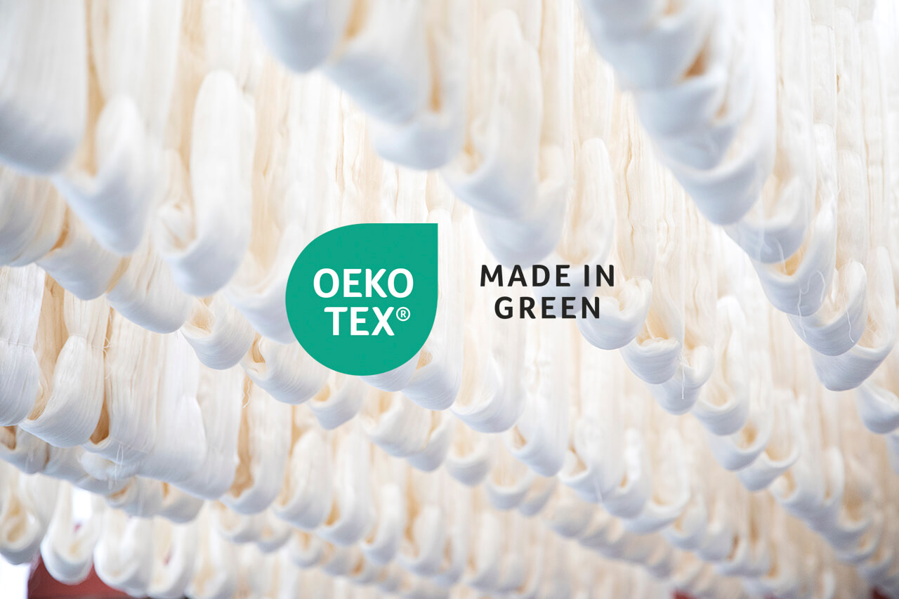 Hanging silk fibers with OEKO-TEX® and MADE IN GREEN labels, ensuring eco-friendly and sustainable silk production