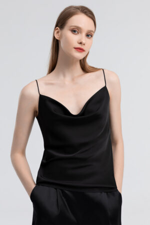 Confident woman showcasing a classic black silk camisole with delicate straps and a smooth silhouette.