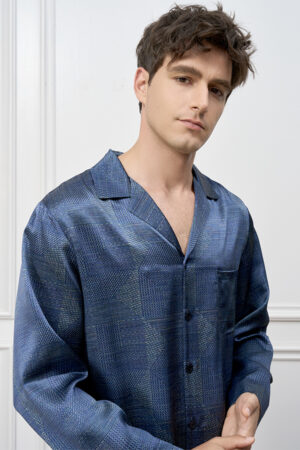 Close-up of model in MANITO Cube Men's Pajama Set with relaxed expression, highlighting the smooth geometric silk fabric.