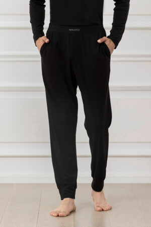 Man wearing black athletic silk track pants with comfortable waistband.