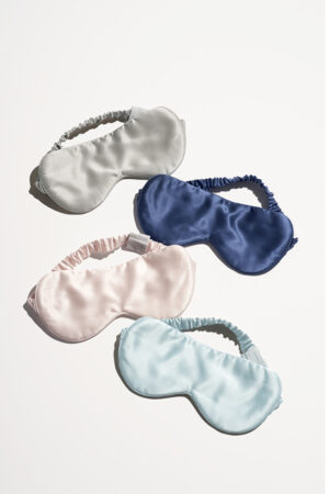 Set of four Light Eye Masks in gray, navy, pink, and blue silk, showcasing elegant satin colors and featherlight design.