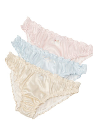 Stacked display of three MANITO DISNEY Cheshire Daisy briefs in pink, blue, and ivory, with ruffled trim and playful Alice illustrations.