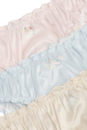 Close-up of MANITO DISNEY Cheshire Daisy Briefs showing delicate Alice and daisies illustrations on pink, blue, and ivory silk.
