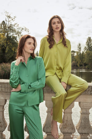 Two women posing in Vibrant Silk Shirt Collection, featuring bold green and yellow tones.