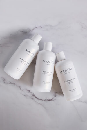 Three bottles of MANITO Delicate Care Liquid Laundry Soap displayed on elegant marble surface, designed for silk and fine fabrics.