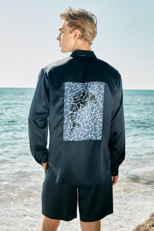 Back view of model in MANITO Ocean Blue Dolphin Men's Pajama Set showing dolphin graphic panel.