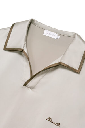 Close-up of MANITO Ribbon Men's Polo Silk Pajama Set showing contrast piping on collar and embroidered logo.
