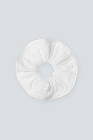 Overview of MANITO Silk Terry Scrunchie with a soft, plush texture and a subtle branded tag, displayed on a light gray background.