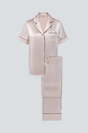 Flat lay of blush pink MANITO Authentic Short Sleeve Pajama Set with black piping and relaxed cut.
