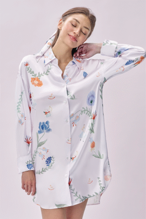 Woman wears Alice Fantasy Forest Long Sleeved Shirt with a soft smile, silky drape cooling the skin for lazy morning comfort.