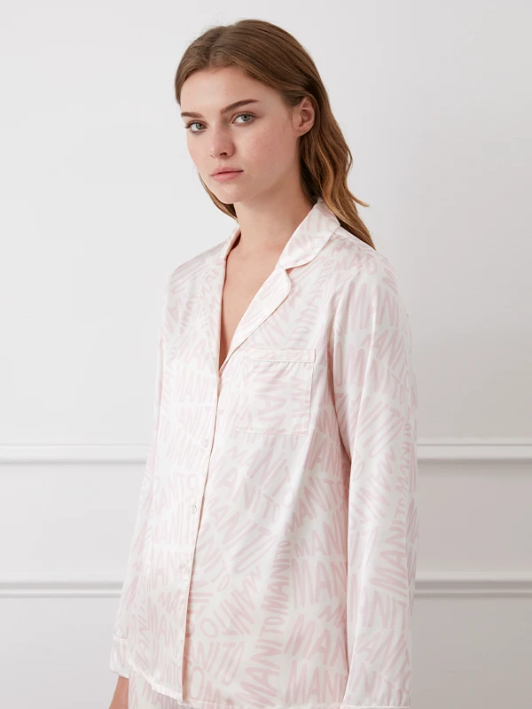 Model in MANITO pink monogram print silk pajama set with a relaxed silhouette.